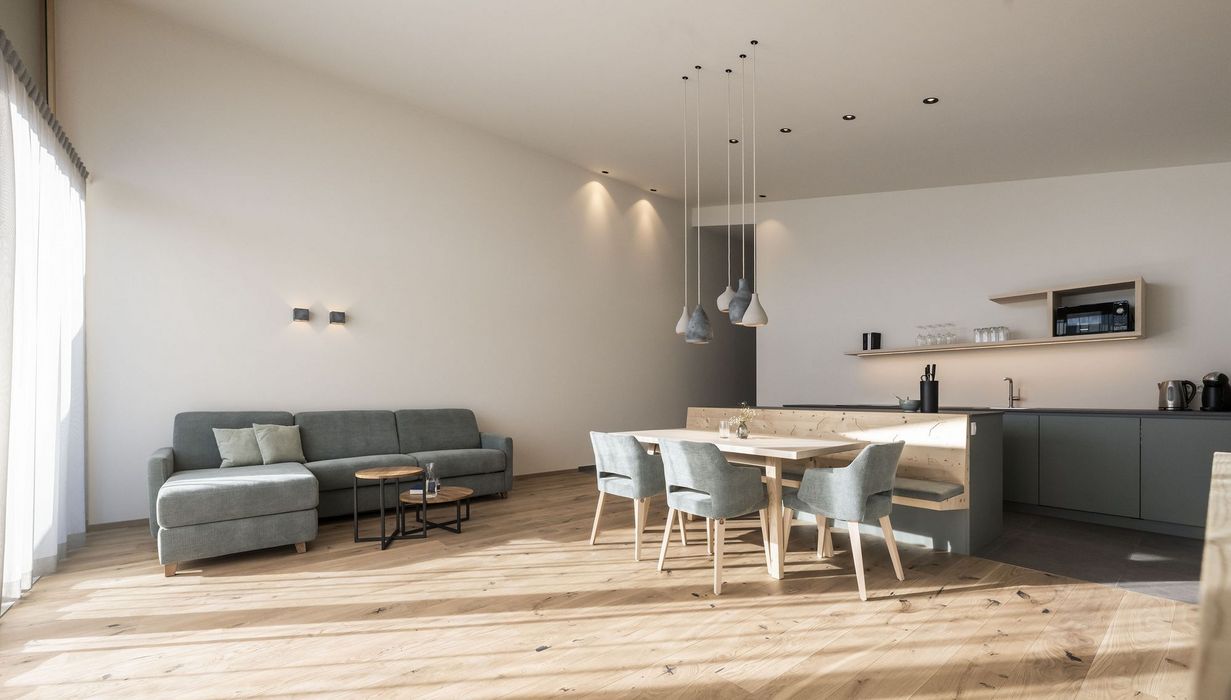 Heller, moderner Wohn- und Essbereich mit grauem Sofa, Holztisch und Küchenzeile in neutralen Farben.
